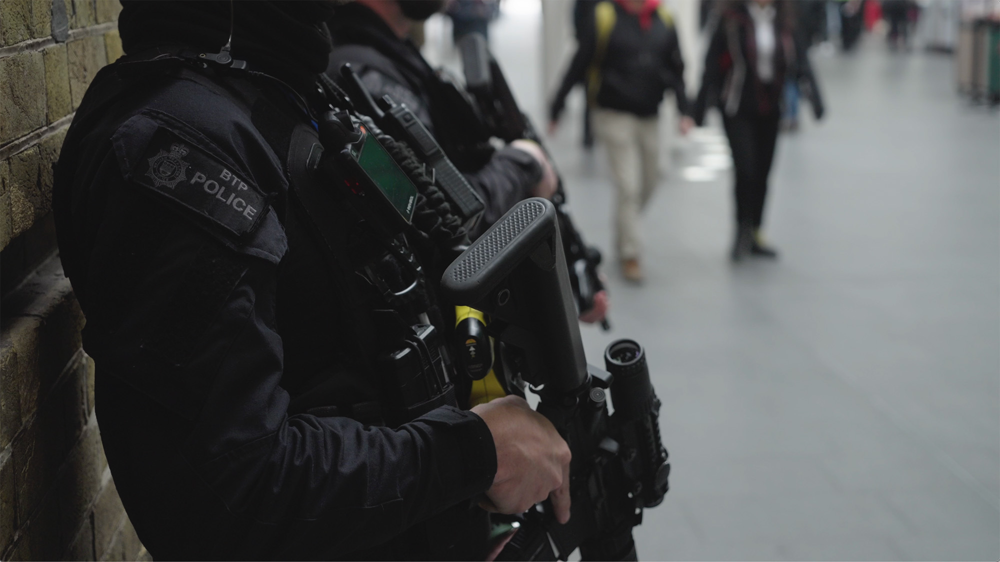 British Transport Police officers in tactical gear standing in a public transit area during a high-visibility security operation
