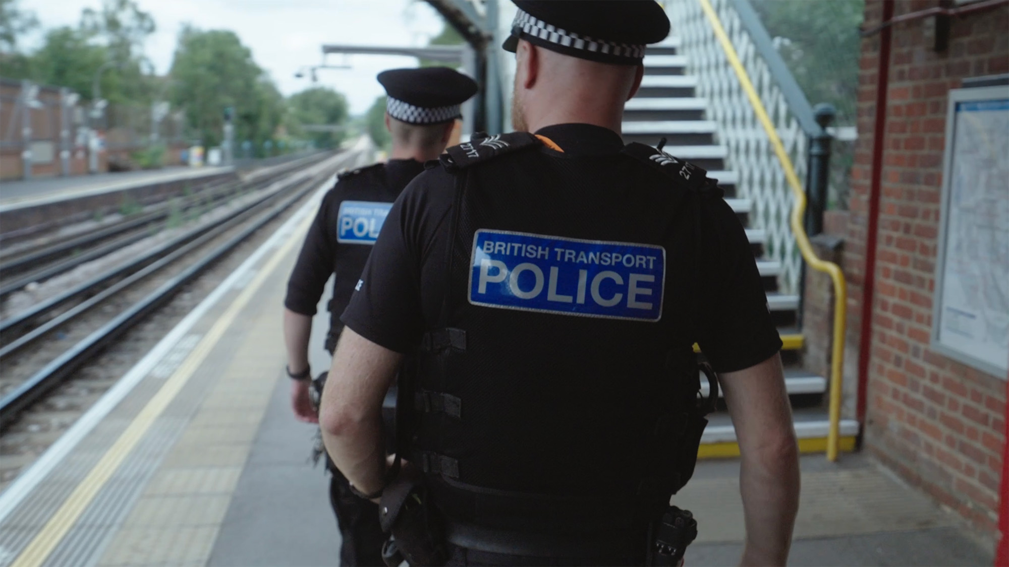 Police officers patrolling a train station platform in London