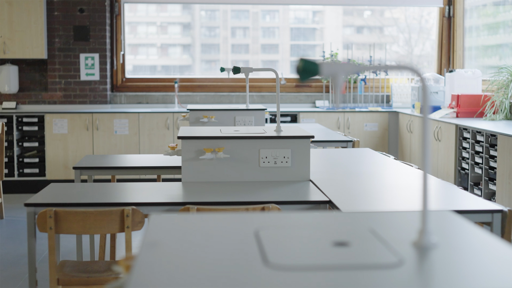 Modern science lab classroom with benches, gas taps, sinks and storage cabinets for equipment