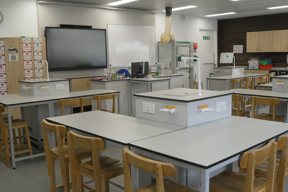 Modern science lab classroom with benches, gas taps, sinks and storage cabinets for equipment