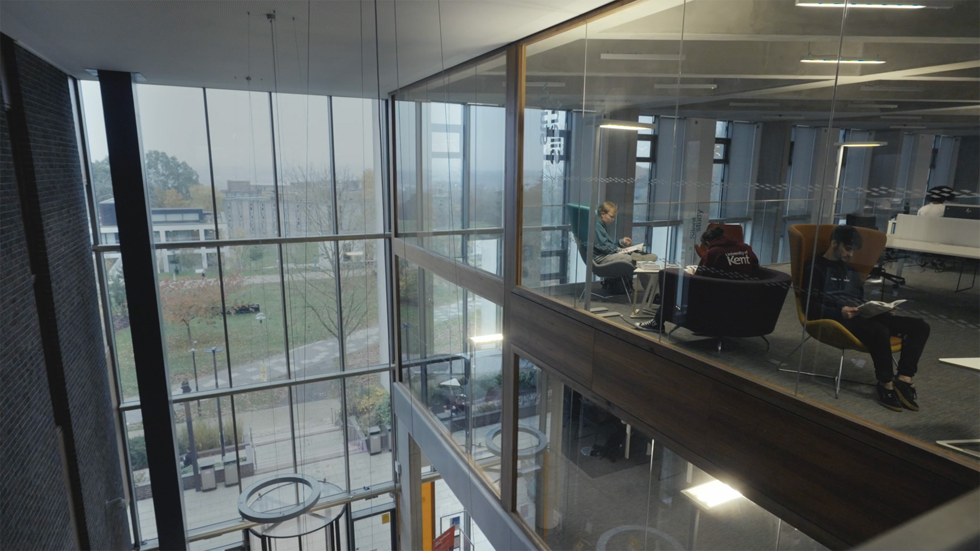 Contemporary university study space with glass-walled meeting area, representing student support, guidance and education progression