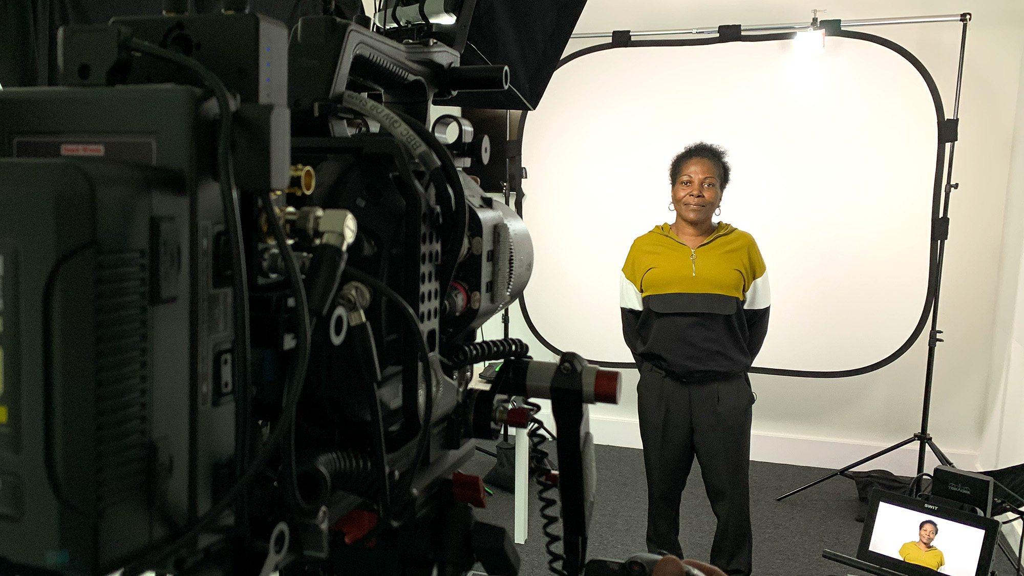 Studio filming scene for Medthority Learning and Development content, showing a person in front of a white backdrop with a camera operator, professional lighting and monitoring equipment