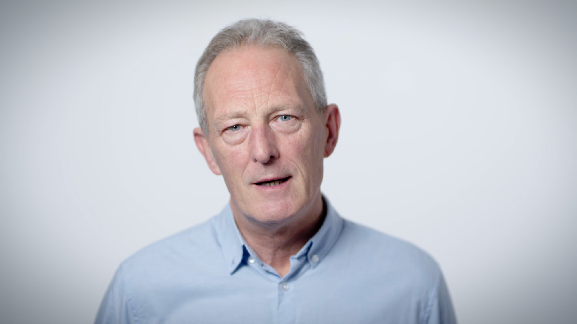 Well-lit portrait used in Medthority smoking cessation Learning and Development content, showing an older adult in a light blue shirt against a simple light background