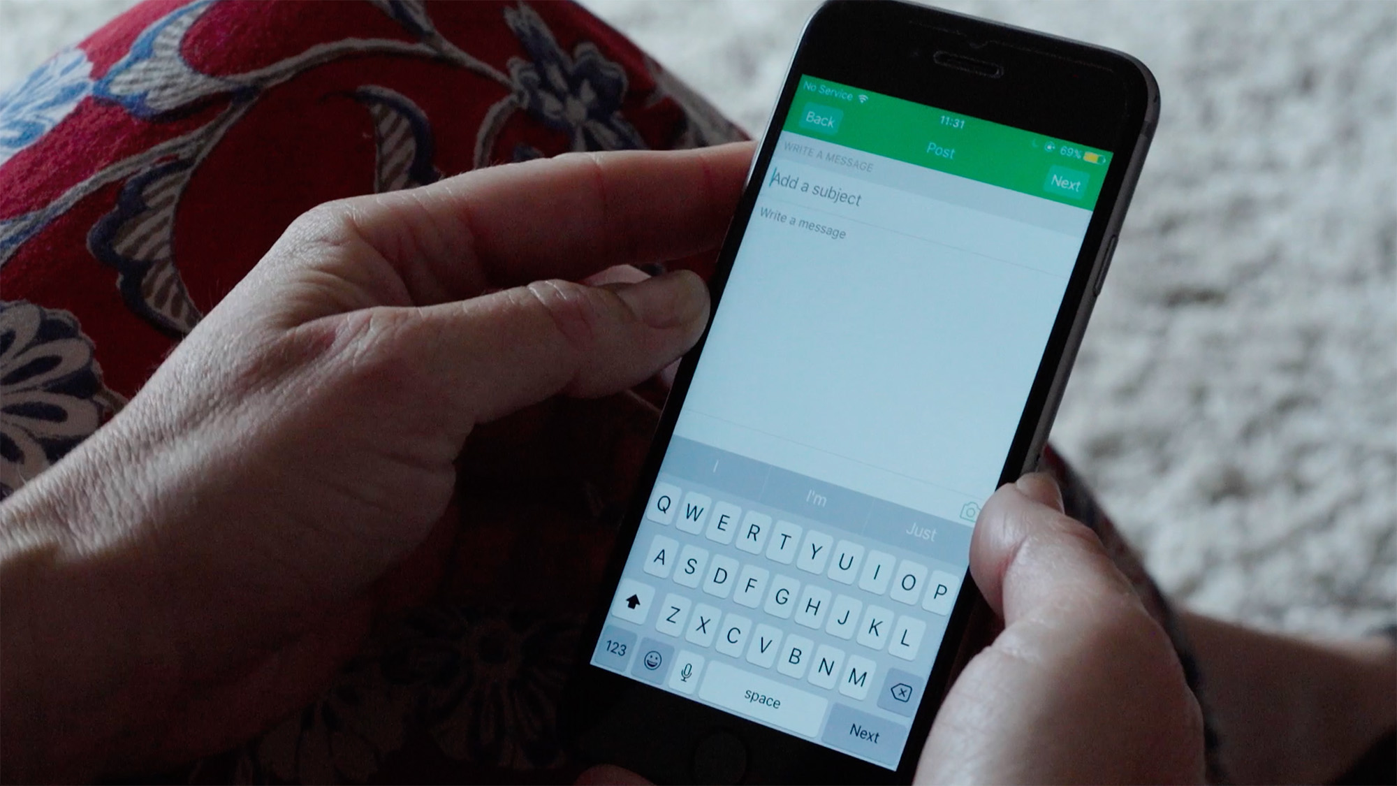 Close‑up of hands holding a smartphone while typing a message on the screen